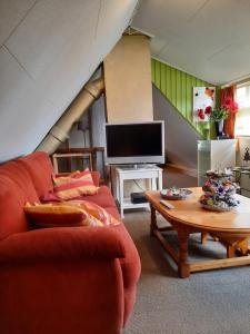 uma sala de estar com um sofá vermelho e uma mesa de centro em familiehuis Benboverijssel em Haaksbergen