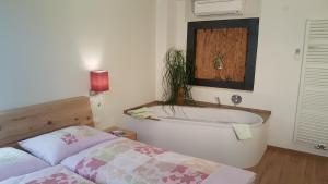 a bedroom with a bath tub and a bed at viaDolceVita - Grüne Gästewohnung in Lana