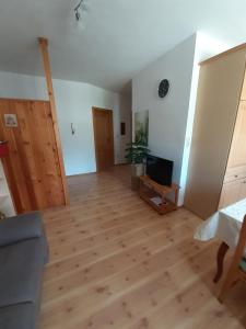 uma sala de estar com piso em madeira e uma televisão em Landhof Lydia em Roggendorf