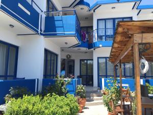 a blue and white house with blue balconies and plants at Anastasia Studios, Apartments & Suites in Archangelos