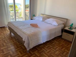 een slaapkamer met een groot wit bed en een balkon bij Roca Apartments in Vodice