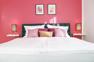 a red bedroom with a white bed with pink walls at Villa Grand Pinea in Čilipi