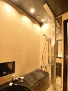 a bathroom with a shower and a sink and a tub at Matsui-Bekkan Hanakanzashi in Kyoto