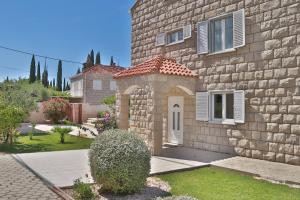 a stone house with a door and a yard at Villa Grand Pinea in Čilipi