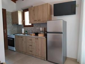 a kitchen with a stainless steel refrigerator and wooden cabinets at Villa Arktos in Nydri
