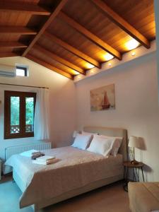 una camera con un grande letto in una stanza con soffitti in legno di Villa Arktos a Nydri