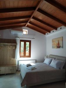 a bedroom with a bed and a window and wooden ceilings at Villa Arktos in Nydri