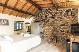 a bedroom with two beds and a stone wall at Sa Crai B&B - Sardinian Experience in Lotzorai