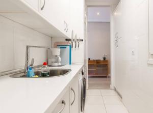 a kitchen with a sink in a white kitchen at Vivienda Turística de Prestancia junto a la Ría de Nervión Bilbao in Bilbao