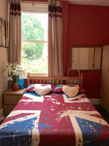 Bett in einem Schlafzimmer mit Fenster in der Unterkunft 38 Whitehall Road in Harrow on the Hill