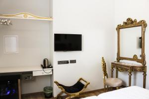 ein Schlafzimmer mit Spiegel, Stuhl und Bett in der Unterkunft 9 Muses Hotel in Larnaka