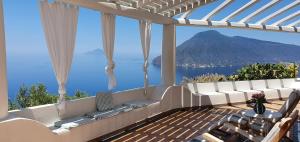 a balcony with a view of the ocean and mountains at Villa Petrara in Acquacalda