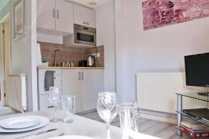 a kitchen with a table with wine glasses on it at Northlands Farm Superior Chalet 3 in Chichester