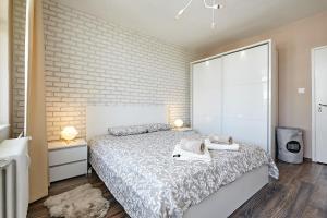 1 dormitorio con cama y pared de ladrillo en Sunset Smart Home en Varna