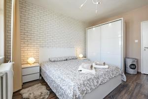 a bedroom with a bed and a brick wall at Sunset Smart Home in Varna City