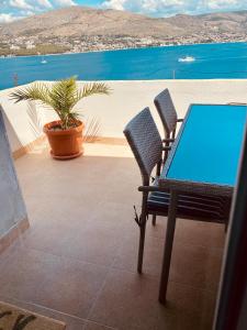 a table and chairs on a patio with a view of the water at apartment Elena in Okrug Donji