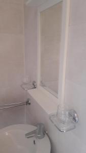 a white bathroom with a sink and a mirror at De indiaan in Noord-Scharwoude