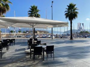 a patio with tables and chairs under a white umbrella at Estudio Parking Centro Puerta del Sol in Vigo