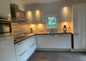 a kitchen with white cabinets and a window at Mariposa in Otterlo