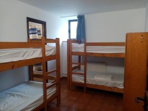 a room with three bunk beds and a mirror at Albergue La Posada Cangas de Onis in Cangas de Onís