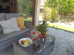 a glass table with a bowl of fruit and drinks on a couch at Protopapas House in Kato Amiandos
