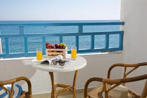 una mesa con copas de zumo de naranja y fruta en el balcón en Elalia Apartments, en Hersonissos 16 fotos más
