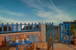 einen Tisch auf einem Balkon mit einem blauen Zaun in der Unterkunft Elalia Apartments in Hersonissos