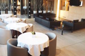a restaurant with white tables and couches and chairs at Golf Hotel Milano in Opera