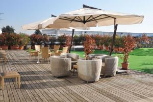 a patio with tables and chairs and an umbrella at Golf Hotel Milano in Opera