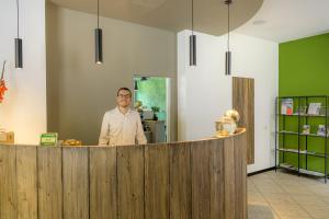 a man standing behind a counter in a room at Hotel La Rotonda in Tirano