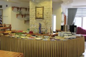 una mesa con muchos platos de comida. en Rain Hotel, en Kızkalesi