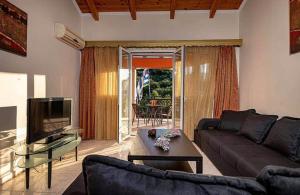 a living room with a couch and a tv at Tsiolis Studios & Apartments in Tsilivi