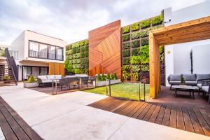un patio al aire libre con muebles y una pared verde en Villa Esmeralda, en Ponta Delgada
