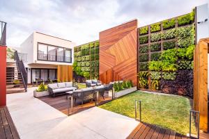 un patio trasero con un jardín vertical en el lateral de un edificio en Villa Esmeralda en Ponta Delgada