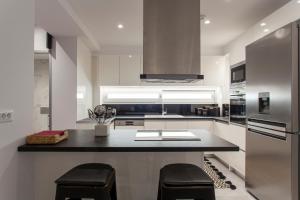 a kitchen with a counter with two stools in it at Emfasis Loft Spacious and Elegant Heraklion in Heraklio Town