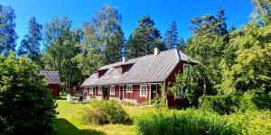 a red house in the middle of a field at Kuus Tuba in Leisi