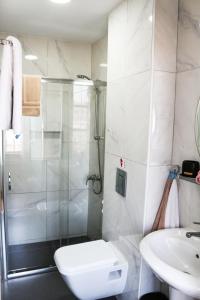 a bathroom with a shower and a toilet and a sink at 9 Muses Hotel in Larnaca