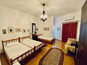 a bedroom with two beds and a chandelier at Eleutheria Rooms in Igoumenitsa