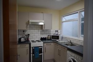 a kitchen with a stove and a sink and a window at Riverside 2 in Dartmouth