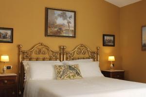 a bedroom with a bed with white sheets and two lamps at Iride Bed and Breakfast in Baronissi