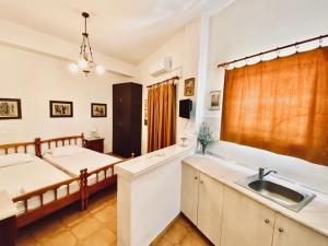 a kitchen with two beds and a sink in a room at Eleutheria Rooms in Igoumenitsa