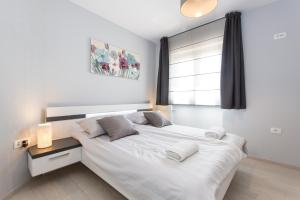 a bedroom with a large white bed and a window at Niki in Labin +16 photos