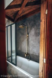 a bathroom with a bath tub with a shower at Suite Prestige Château Uriage - Escapade romantique in Saint-Martin-dʼUriage