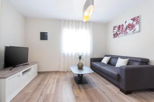 a living room with a couch and a tv at Niki in Labin