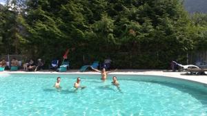 een groep kinderen die zwemmen in een zwembad bij Sport'Hotel-Aparthotel de Milan in Le Bourg-dʼOisans