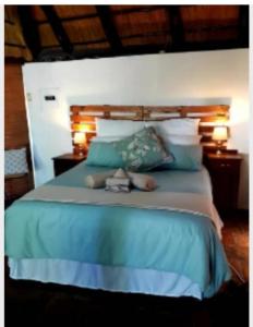 a bedroom with a blue bed with two lamps at The Lapa Apartment in Gobabis
