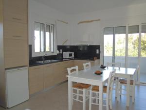 - une cuisine avec une table et une table et des chaises blanches dans l'établissement Petaloudes, à Kamilárion