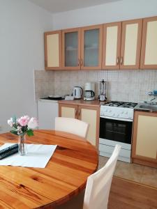 a kitchen with a wooden table with white appliances at Apartments Jure in Smoljanac