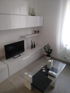 salon z telewizorem na białej ścianie w obiekcie Angel B&B w mieście Potenza Picena