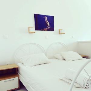 two white beds in a room with a picture on the wall at Spanos Apartments in Agios Petros
